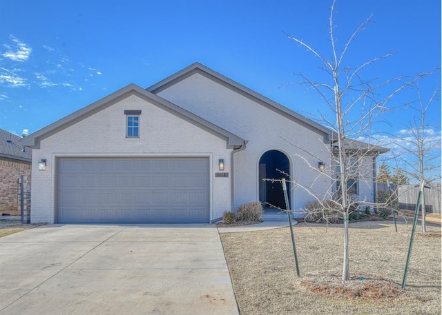 single story home featuring brick siding, driveway, and an attached garage