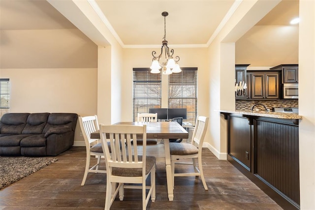 dining room featuring a notable chandelier, ornamental molding, dark hardwood / wood-style flooring, and a wealth of natural light