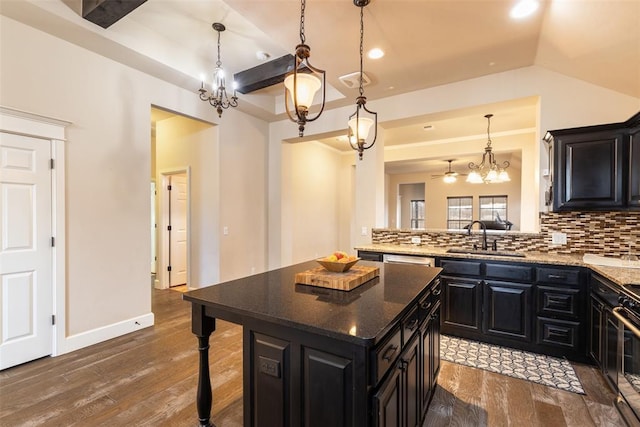 kitchen with sink, a kitchen island, hanging light fixtures, and decorative backsplash