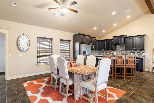 dining room featuring ceiling fan, sink, and vaulted ceiling