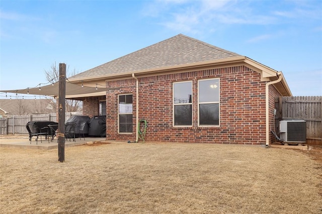 rear view of property with a patio area, central AC unit, and a lawn