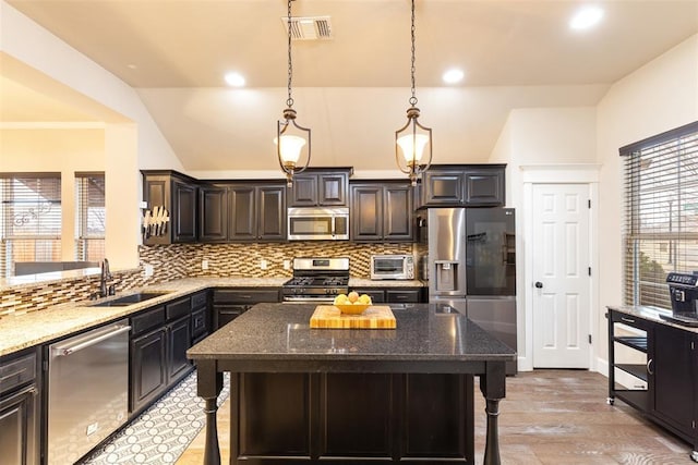 3524 Mount Mitchell Ln, Norman, OK 73069 - kitchen with stainless steel appliances, a sink, dark stone counters, tasteful backsplash, and lofted ceiling