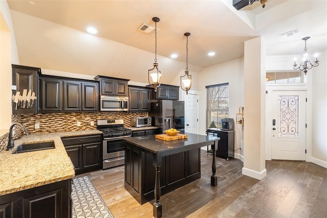 3524 Mount Mitchell Ln, Norman, OK 73069 - kitchen featuring stainless steel appliances, a sink, a kitchen bar, backsplash, and light stone counters