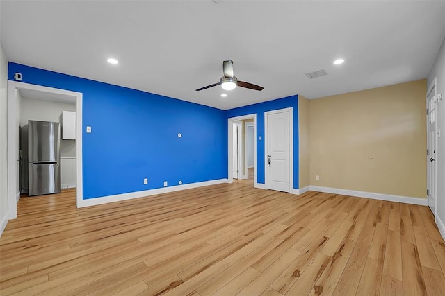 unfurnished bedroom featuring ceiling fan, stainless steel refrigerator, and light hardwood / wood-style floors