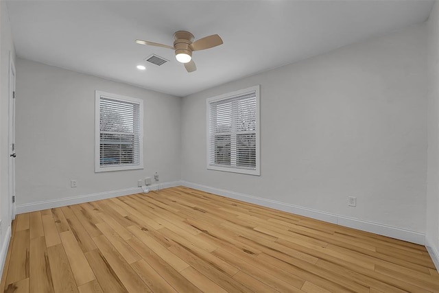 spare room featuring ceiling fan, light hardwood / wood-style flooring, and a wealth of natural light