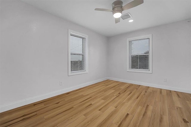 spare room featuring plenty of natural light, ceiling fan, and light hardwood / wood-style flooring