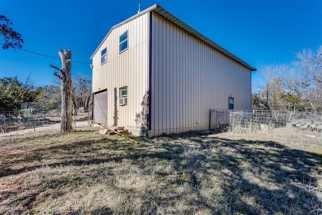 view of side of home featuring cooling unit and a garage