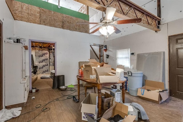 interior space featuring hardwood / wood-style flooring, ceiling fan, and a high ceiling