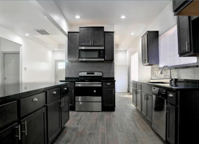 kitchen featuring sink, decorative backsplash, dark wood-type flooring, and appliances with stainless steel finishes