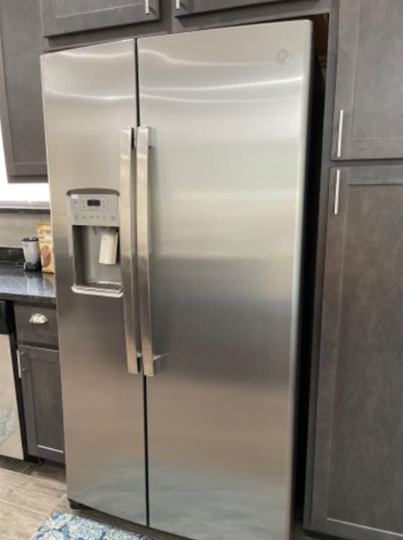 kitchen with light hardwood / wood-style floors and stainless steel fridge with ice dispenser