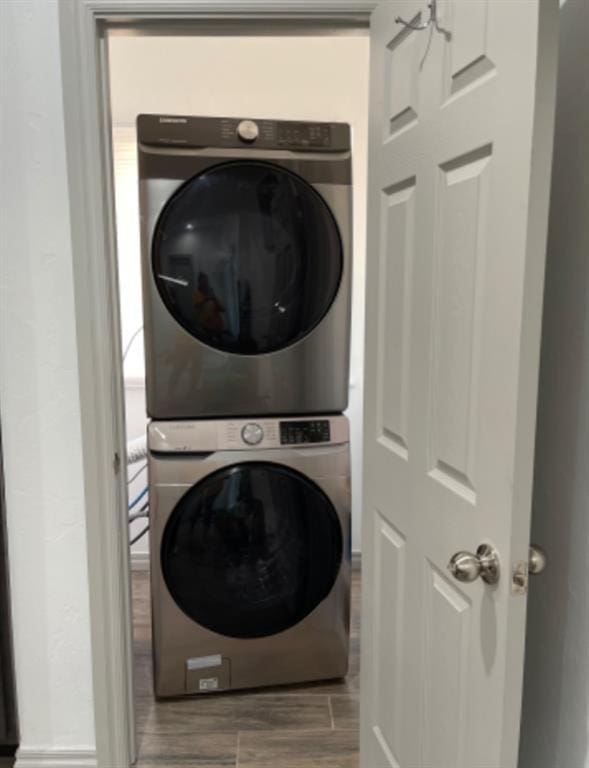 clothes washing area featuring stacked washing maching and dryer