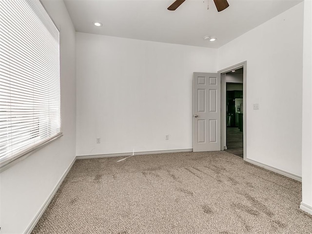 carpeted empty room with recessed lighting, a ceiling fan, and baseboards