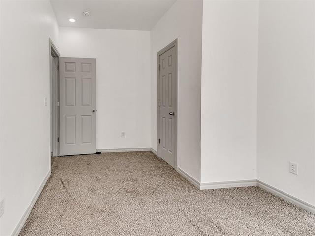 empty room with recessed lighting, light carpet, and baseboards