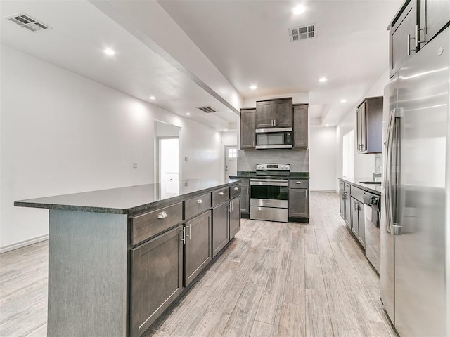 kitchen with stainless steel appliances, dark countertops, and visible vents