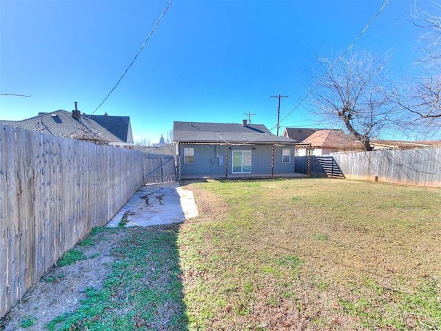 back of property featuring a fenced backyard and a yard