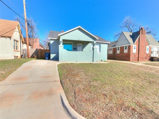 view of front of house featuring a front yard, fence, and stucco siding