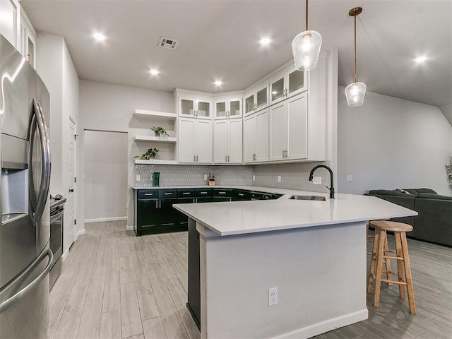 kitchen featuring sink, white cabinetry, decorative light fixtures, stainless steel appliances, and backsplash