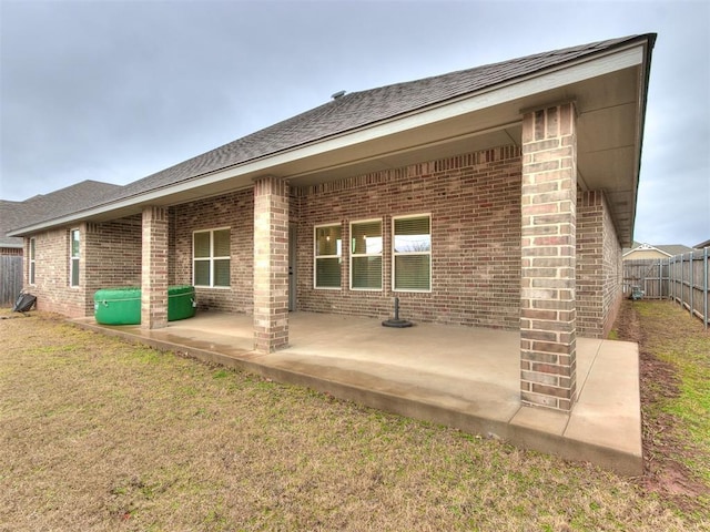 back of house featuring a lawn and a patio