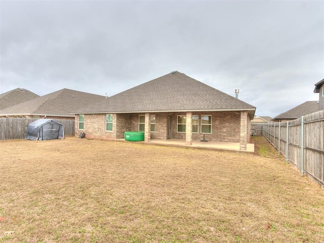 rear view of house with a yard and a patio area