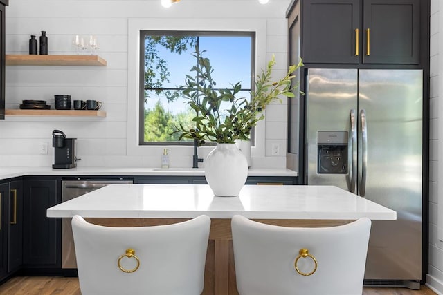 kitchen featuring stainless steel appliances, sink, light wood-type flooring, and a wealth of natural light