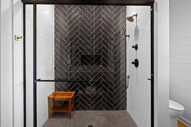 bathroom featuring a tile shower and toilet