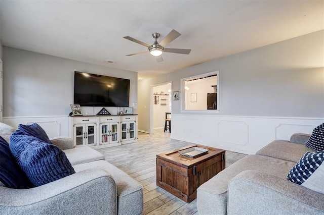 living room featuring ceiling fan and light hardwood / wood-style flooring