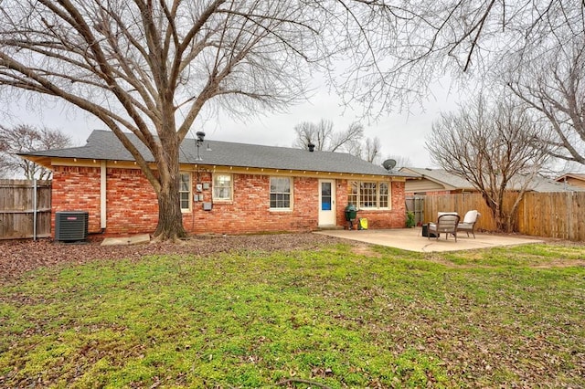 rear view of house with a lawn, cooling unit, and a patio area