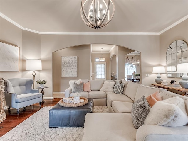 living room with dark hardwood / wood-style flooring, ornamental molding, and an inviting chandelier