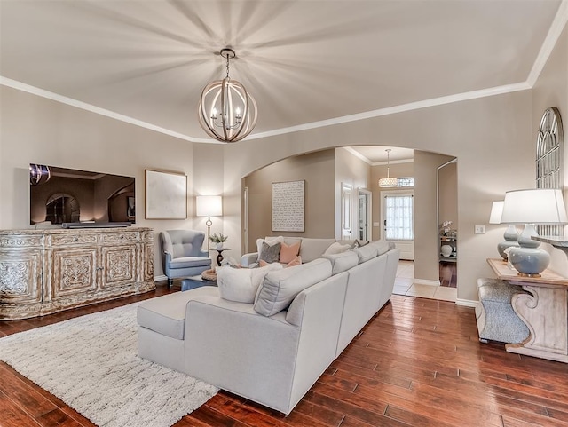 living room featuring crown molding, dark hardwood / wood-style flooring, and a notable chandelier