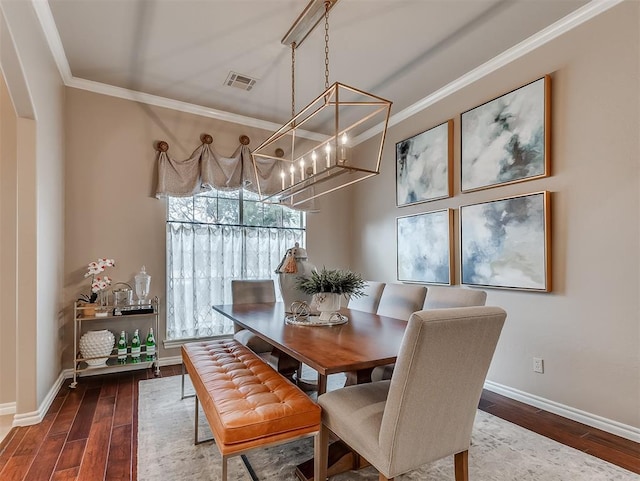 dining room with wood-type flooring and crown molding