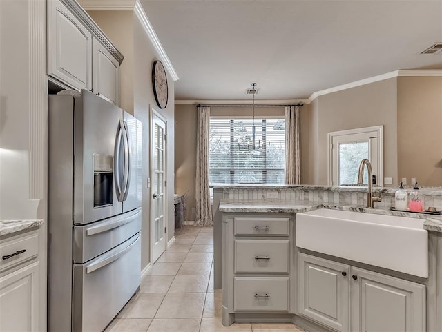 kitchen with ornamental molding, stainless steel fridge, sink, and white cabinets