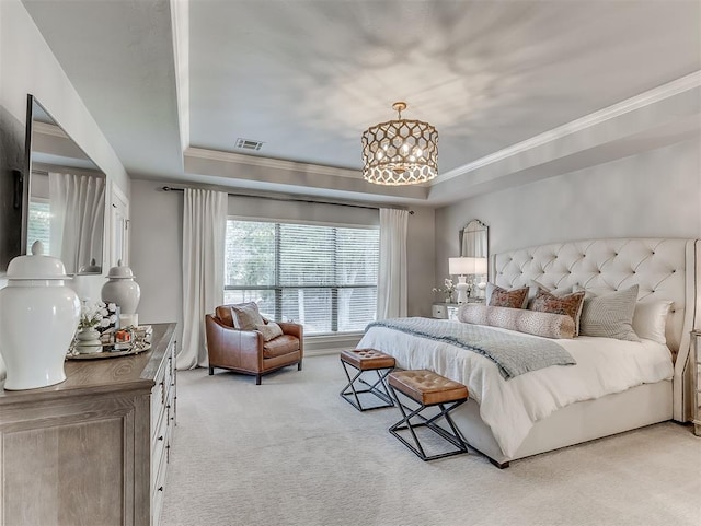 carpeted bedroom with a notable chandelier, a tray ceiling, and ornamental molding