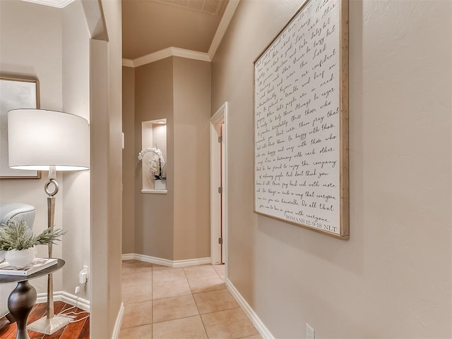 hall with crown molding and light tile patterned floors