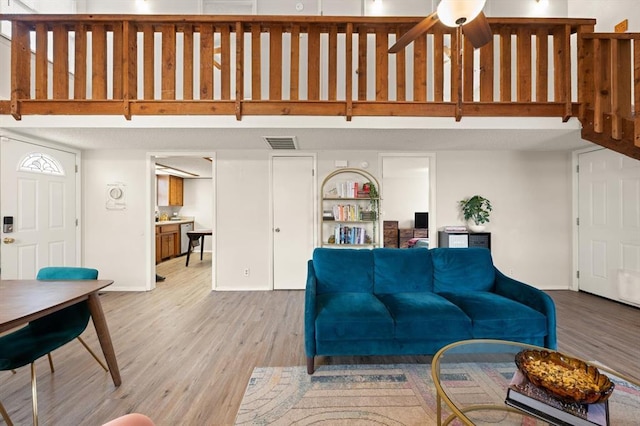 living room with light hardwood / wood-style flooring and ceiling fan