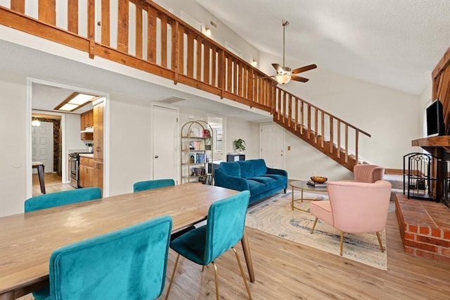 dining room featuring light hardwood / wood-style flooring, high vaulted ceiling, and ceiling fan