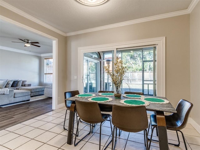 dining space with light tile patterned floors, plenty of natural light, and ornamental molding