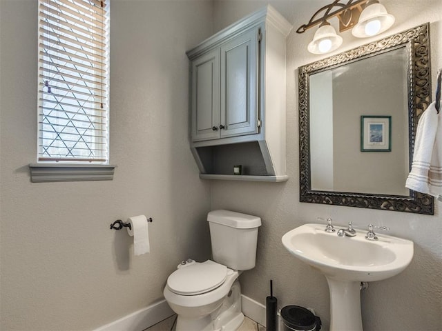 bathroom featuring baseboards and toilet