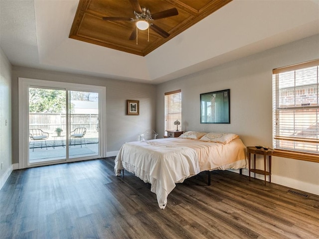 bedroom with baseboards, visible vents, dark wood-type flooring, access to exterior, and a tray ceiling