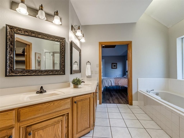 full bath featuring double vanity, a stall shower, tile patterned flooring, and a sink