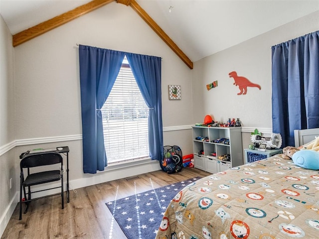 bedroom featuring lofted ceiling, visible vents, baseboards, and wood finished floors