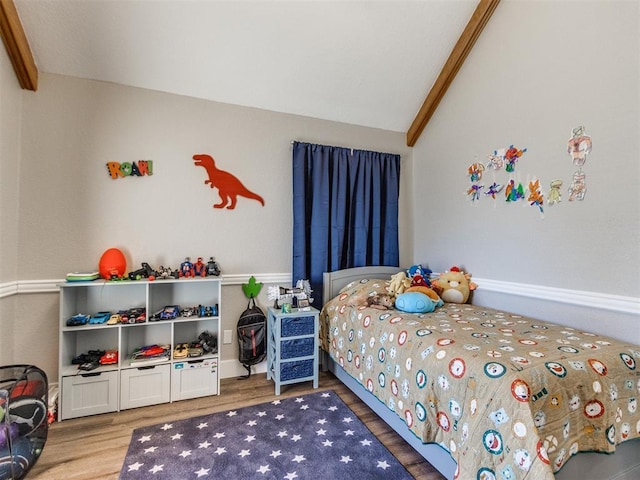 bedroom featuring vaulted ceiling with beams and wood finished floors