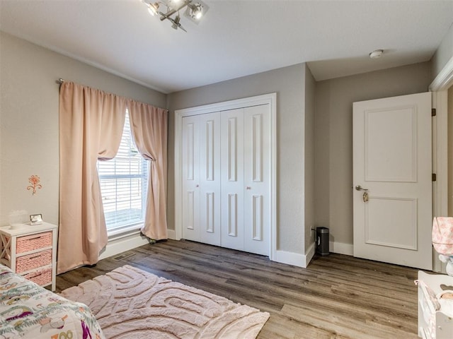 unfurnished bedroom with a closet, baseboards, and wood finished floors