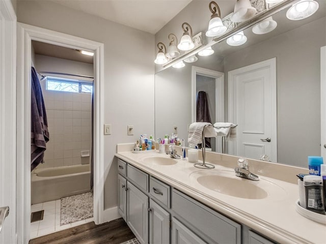 bathroom featuring double vanity, baseboards, and a sink