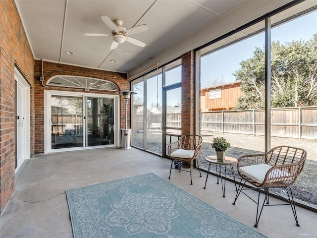 sunroom / solarium featuring a ceiling fan