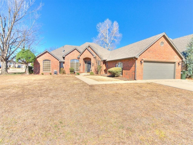 view of front of home with a garage, a front lawn, concrete driveway, and brick siding