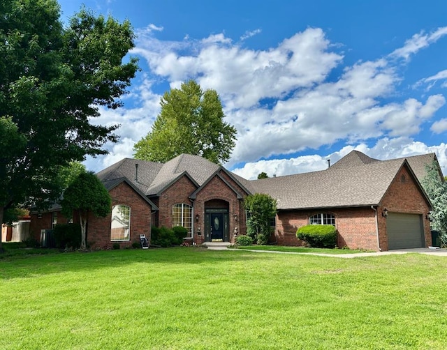 3801 Waverly Ct, Norman, OK 73072 - view of front of property featuring a front yard, brick siding, an attached garage, concrete driveway, and roof with shingles