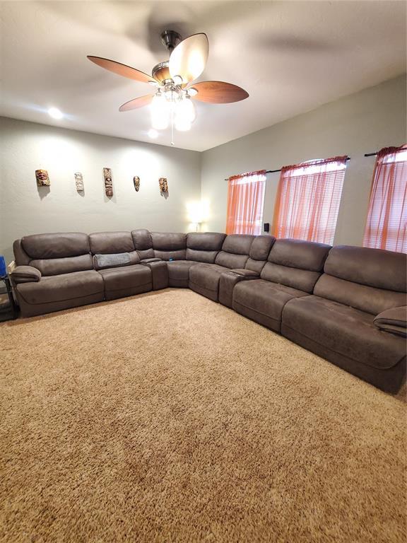 unfurnished living room with ceiling fan