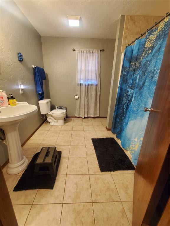 bathroom with a textured ceiling, tile patterned floors, toilet, and a shower with shower curtain