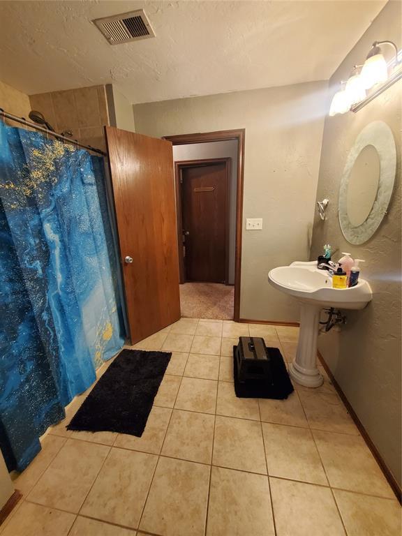 bathroom with a shower with curtain, tile patterned floors, and a textured ceiling