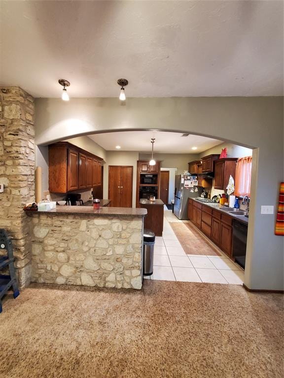 kitchen with pendant lighting, stainless steel fridge, a breakfast bar, dishwasher, and kitchen peninsula